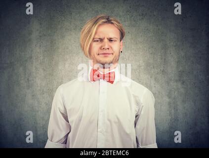 Der Mann ärgerte sich verärgert grimacing mit Abscheu sein Gesicht isoliert auf grauem Hintergrund. Stockfoto