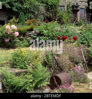 Vintage Eisen Garten Roller gegen niedrige Steinwand lehnend Stockfoto