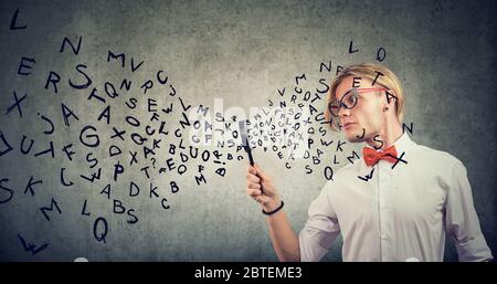 Neugieriger nerdiger Mann mit Lupe studiert Stockfoto