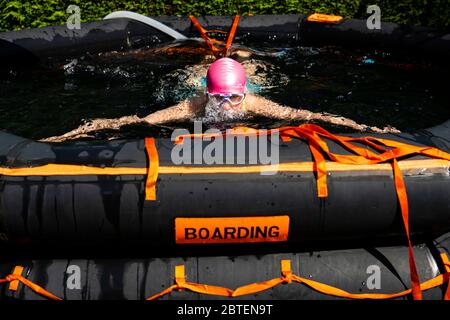 Uphall, Schottland, Großbritannien. 25 Mai 2020. Emily Aston, eine wilde Freiwasser-Schwimmerin mit der Gruppe der Fufe Wild Schwimmer, während eines täglichen Tauchens in ihrem Gartenpool, der aus einem Schiffsfloß gemacht wurde. Vielen Wildschwimpern wurde die Möglichkeit verwehrt, während der Sperrung von Covid-19 ihren Sport zu treiben, und sie haben Pools für ihre Gärten gekauft, um ihr Wohlbefinden zu erhalten. Iain Masterton/Alamy Live News Stockfoto