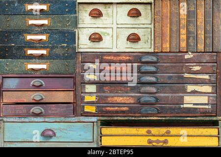 Bunte Auswahl an Vintage Holzschubladen und Bücher mit Etiketten und Griffen Stockfoto
