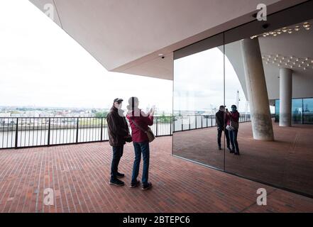 Hamburg, Deutschland. Mai 2020. Auf dem Platz der Elbphilharmonie, der wegen des Coronavirus vorübergehend geschlossen und am 25.05.2020 wieder eröffnet wurde, stehen Besucher in der Ferne. Kredit: Daniel Bockwoldt/dpa/Alamy Live News Stockfoto