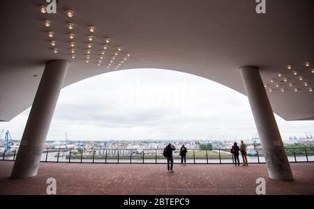 Hamburg, Deutschland. Mai 2020. Auf dem Platz der Elbphilharmonie, der wegen des Coronavirus vorübergehend geschlossen und am 25.05.2020 wieder eröffnet wurde, stehen Besucher in der Ferne. Kredit: Daniel Bockwoldt/dpa/Alamy Live News Stockfoto