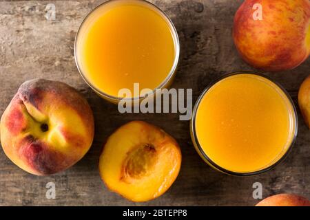 Natürlicher Pfirsichsaft aus Glas auf Holztisch.Draufsicht Stockfoto