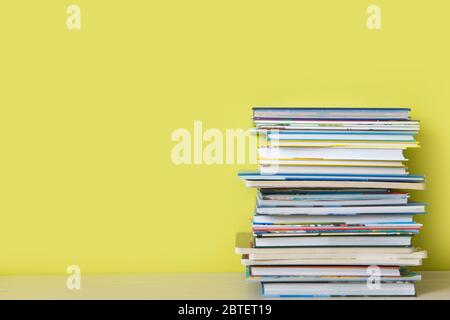 Viele Kinderbücher sind übereinander gestapelt. Grüner Hintergrund. Stockfoto