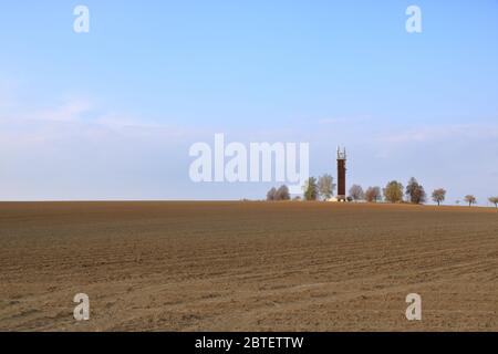 Hölzerner Fernmeldeturm mit Sendern. Mobilfunk-Basisstation mit Sendeantennen auf Telekommunikationsturm auf gegen einen blauen Himmel mit Stockfoto