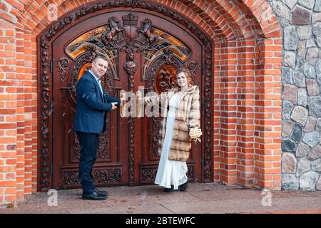 Frisch verheiratetes Paar, das am frühen Frühlingstag in der Nähe der Burgtür im Stadtpark steht Stockfoto