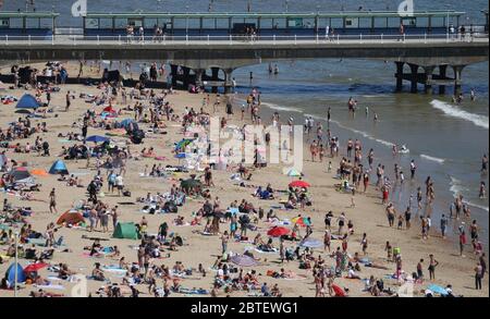 Die Menschen genießen das heiße Wetter am Bournemouth Strand in Dorset, nachdem Maßnahmen eingeführt wurden, um das Land aus der Blockierung zu bringen. Stockfoto