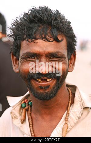 Porträt eines glücklichen Mannes lächelnd und Blick auf die Kamera am Clifton Beach, Karachi, Pakistan 26/06/2012 Stockfoto