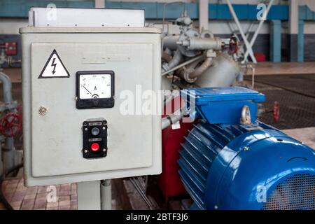 Start- und Stopp-Taste für die industrielle Maschinenschließanlage auf dem elektrischen Bedienfeld im Innenraum der chemischen Anlage, in der Nähe von Motor der Pumpe oder Kompres Stockfoto