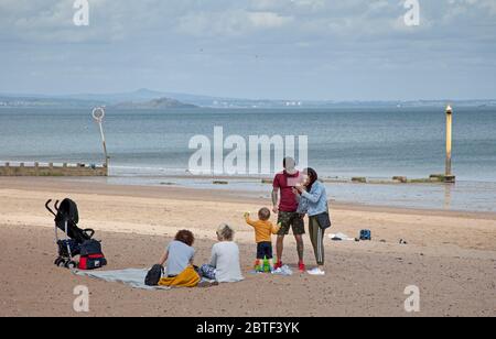 UK Wetter, sonniger und luftiger Feiertag montag in Portobello, Edinburgh, Schottland. 25 Mai 2020. Zwei Polizisten auf der Promenade üben eine leichte Berührung, ohne jemanden zu stören, der sich hinsetzte, möglicherweise ist dies die letzte Woche voller Lockdown.19 Grad mit einer frischen Brise. Quelle: Arch White /Alamy Live News Stockfoto