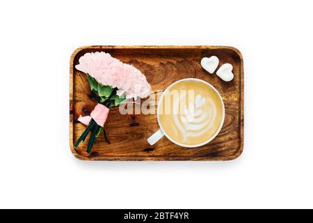 Tasse Kaffee mit Strauß Rosen und ein Stück Zucker auf Holztablett. Morgenkaffee Zusammensetzung. Stockfoto