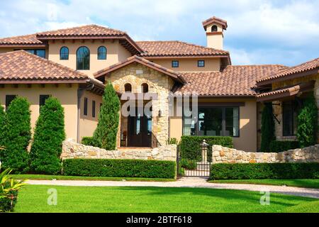 Wunderschönes Haus im spanischen Stil mit Natursteinseite und Furnierverkleidungs und einem makellos gepflegten Rasen und Landschaftsbau.