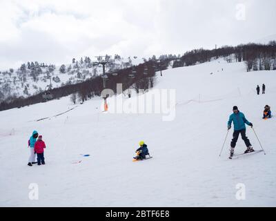 GREVENA, GRIECHENLAND - 24. MÄRZ 2018: Skigebiet Vasilitsa mit Schnee und Menschen auf der Piste bei bewölktem Wetter Stockfoto