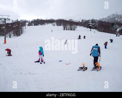 GREVENA, GRIECHENLAND - 24. MÄRZ 2018: Skigebiet Vasilitsa mit Schnee und Menschen auf der Piste bei bewölktem Wetter Stockfoto