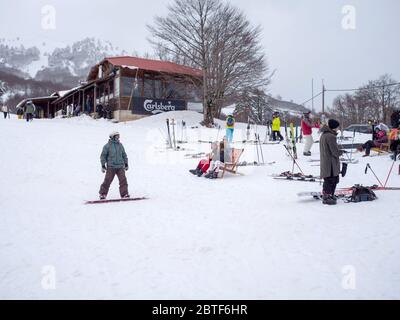 GREVENA, GRIECHENLAND - 24. MÄRZ 2018: Skigebiet Vasilitsa mit Schnee und Menschen auf der Piste bei bewölktem Wetter Stockfoto