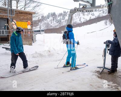 GREVENA, GRIECHENLAND - 24. MÄRZ 2018: Skigebiet Vasilitsa mit Schnee und Menschen auf der Piste bei bewölktem Wetter Stockfoto