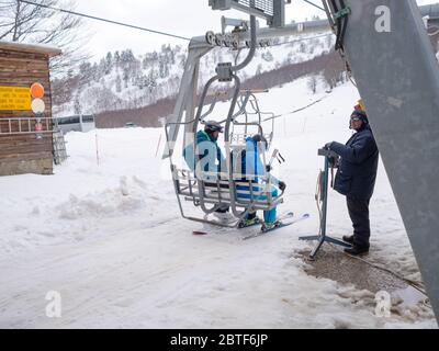 GREVENA, GRIECHENLAND - 24. MÄRZ 2018: Skigebiet Vasilitsa mit Schnee und Menschen auf der Piste bei bewölktem Wetter Stockfoto