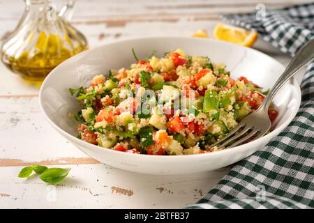 Nahaufnahme von frischem und gesundem veganen Couscous-Salat Weiße Platte Stockfoto