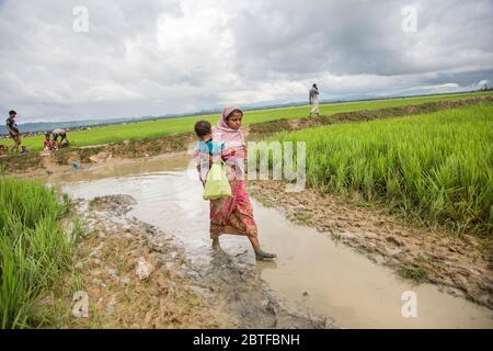 Flüchtlingsmutter und -Kind gehen, Rohingya-Flüchtling in Bangladesch Stockfoto