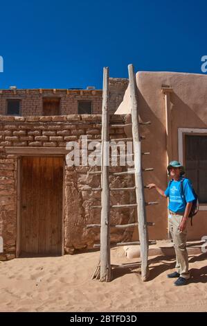Lokaler Guide an der Holzleiter in der Wohnung in Acoma Pueblo (Sky City), Indianerpueblo auf mesa in Acoma Indianerreservat, New Mexico USA Stockfoto