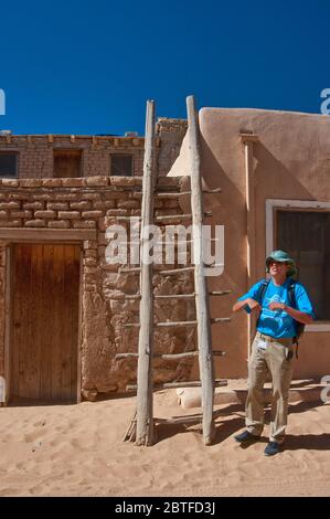 Lokaler Guide an der Holzleiter in der Wohnung in Acoma Pueblo (Sky City), Indianerpueblo auf mesa in Acoma Indianerreservat, New Mexico USA Stockfoto