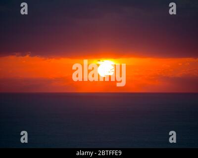 Schöner Sonnenuntergang mit Wolken und schwindende Sonne in den Horizont Stockfoto