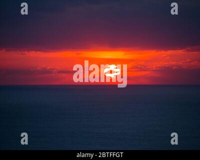 Schöner Sonnenuntergang mit Wolken und schwindende Sonne in den Horizont Stockfoto