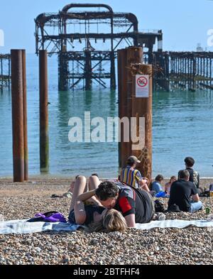 Brighton UK 25. Mai 2020 - Besucher genießen den späten Nachmittag Sonnenschein am Strand und am Meer von Brighton, während das Feiertagswochenende heute an der Südküste während der Coronavirus COVID-19 Pandemie-Krise zu Ende geht. Quelle: Simon Dack / Alamy Live News Stockfoto