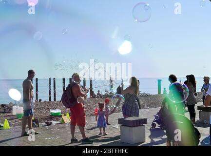 Brighton UK 25. Mai 2020 - EIN Bubble Entertainer in der späten Nachmittagssonne am Strand und am Meer von Brighton, während das Feiertagswochenende heute an der Südküste während der Coronavirus COVID-19 Pandemie-Krise zu Ende geht. Quelle: Simon Dack / Alamy Live News Stockfoto