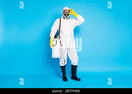 Full length Foto von Arzt Mann in biologischen Schutzuniform bereit stoppen ncov-Infektion Epidemie Ausbreitung haben Spray Ausrüstung über blau isoliert Stockfoto