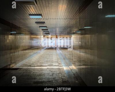 Dunkle städtische Unterführung, langer Tunnel mit Marmorwänden, mobiles Straßenfoto Stockfoto