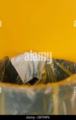 Maske verwendet ist infektiöse Abfälle in der Tonne. Eine Müllmaskenbeseitigung ist falsch Stockfoto