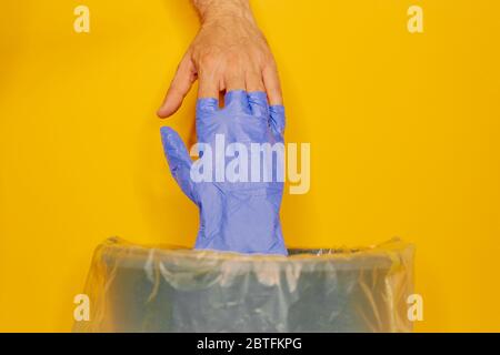 Wegwerfen einmal medizinischen Handschuh. Verpackung in einer einzigen Plastiktüte, bevor Sie es in Müll zu verhindern, dass Viren von Handschuh zu t verbreiten Stockfoto