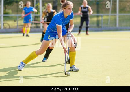 Field Hockey weibliche Spieler führen den Ball in Angriff im Spiel Stockfoto