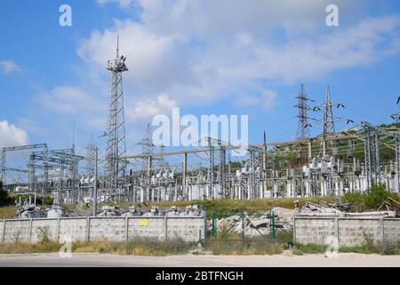 Eine Umspannwerk-Ausrüstung, Transformatoren und Drahtpole. Stockfoto