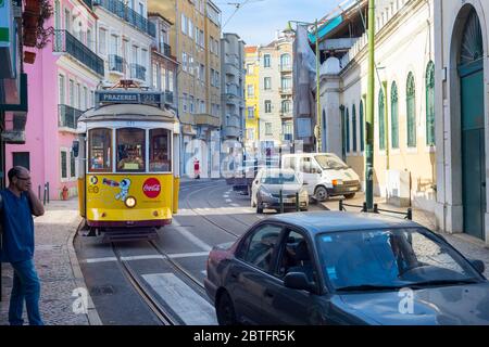 LISSABON, PORTUGAL - 18. SEPTEMBER 2018: Berühmte altmodische Straßenbahn 28 auf einer schmalen Lissabonner Straße, Portugal Stockfoto