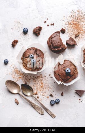Hausgemachte, frische Schokoladenmuffins mit Beeren und Schokoladenstücken. Stockfoto