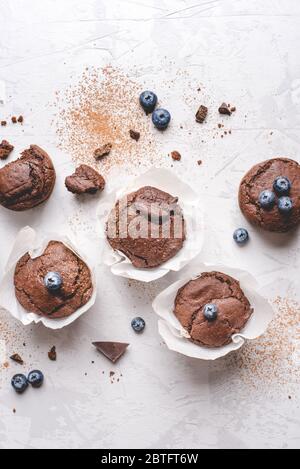 Hausgemachte, frische Schokoladenmuffins mit Beeren und Schokoladenstücken. Stockfoto