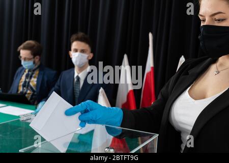 Wahlurne. Ein Umschlag mit einem Stimmzettel. Er wirft den fertigen Stimmzettel in einem Umschlag in die Brust. Stockfoto