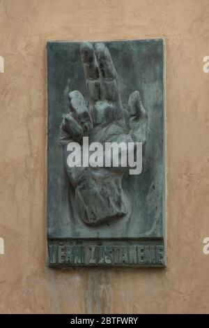 Gedenktafel für die Gefallenen während des Prager Aufstands im Mai 1945 an der Wand der Nikolaikirche (Kostel svatého Mikuláše) auf dem Altstädter Ring in Prag, Tschechische Republik. Die ikonische gesegnete Hand mit der tschechischen Inschrift "Věrni zůstaneme" (Wir werden treu bleiben) wurde vom tschechischen Bildhauer Karel Pokorný (1945) entworfen. Stockfoto