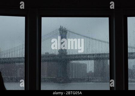 Die Brooklyn Bridge an einem grauen Regentag durch ein Fenster gesehen Stockfoto