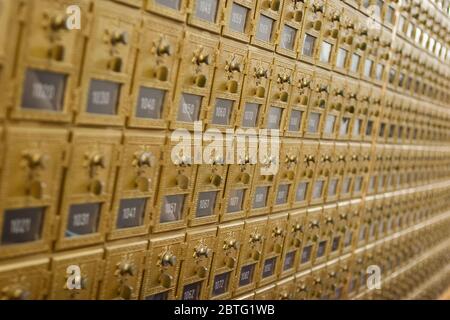 Reihe von Vintage Messing Einsteckfächer mit Türen und Kombination Schlösser in einem Postraum. Stockfoto