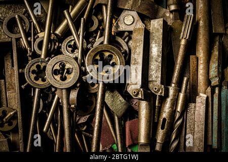 Rostende Stahlwerkzeuge und Gewindewerkzeuge auf dem Tisch in der Metallfabrik Stockfoto