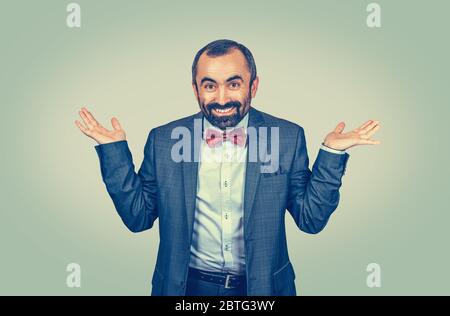 Junge gut aussehende Mann lächelnd zeigt beide Hände offen Palmen, Geschäftsmann trägt formelle weiße Hemd und blaue Jacke über isoliert grün gelben Hintergrund Stockfoto