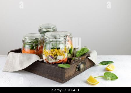 Gesunde vegetarische hausgemachte Mason Jar frischer Salat mit Chickpea und Gemüse in einer Holzkiste auf einem hellen Hintergrund.Diät, Detox, saubere Ernährung, Vegan roh Stockfoto