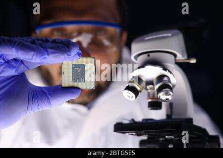 Maskierter Mann untersucht einen Mikrokreis nahe Mikroskop Stockfoto