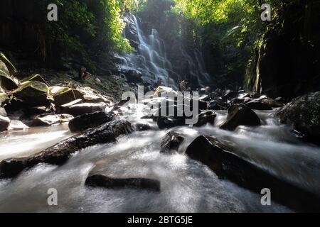 Wunderschöne Szene mit Wasserfall und Sonne, die durch die Bäume in bali indonesien scheint Stockfoto