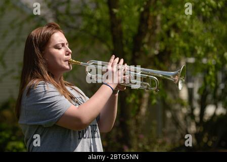 25. Mai 2020, Elburn, Illinois, USA: BAILEY CATES, 17 of Elburn, Illinois Sounds im Vorgarten ihres Hauses mit ihrer Trompete, als Teil des Tap Across America Events. Mit Gedenkfeierlichkeiten und Veranstaltungen, die wegen der COVID-19 Pandemie abgesagt wurden, haben Menschen alternative Wege gefunden, um diejenigen zu ehren, die ihr Leben im Dienst an den Vereinigten Staaten, diesem Memorial Day, hingaben. Veranstaltungen wie Taps in ganz Amerika bitten Musiker aller Fähigkeiten und Alter, Taps auf ihren vorderen Rasen, Veranden und Einfahrten um 15 Uhr Ortszeit Montag, 25. Mai zu klingen.Cates ist ein kürzlich Absolvent Kaneland High Stockfoto