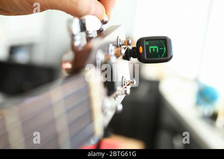 Tuner ist auf Gitarrenhals für Stimmnoten installiert Stockfoto